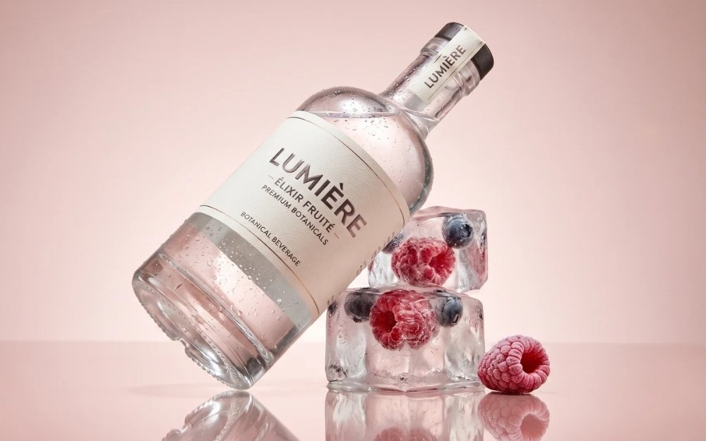 AI product photo of a lip balm tube resting on clear ice cubes with frozen red berries on a blush-pink background
