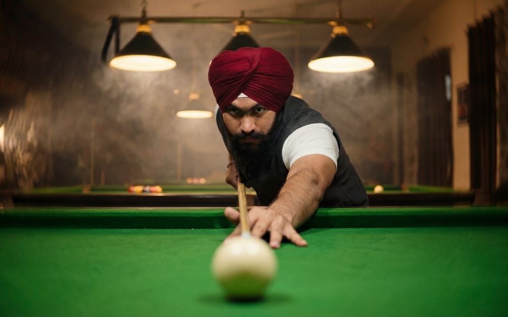 AI cinematic low-angle shot of a man in a maroon turban lining up a pool shot, cue ball sharp in the foreground